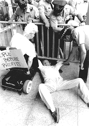 photograph shows activists on the barricades at a Chicago Adapt action.