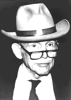 photo of Justin Dart peering over his reading glasses, wearing his trademark Stetson hat.